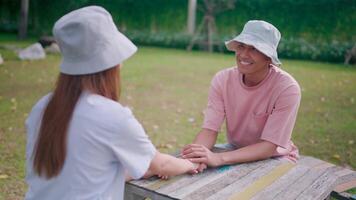 Couple sitting on a table on the balcony, bonding, trusting or supporting love, smiling, happy or talking with a woman and man in a relaxing spring break getaway. video