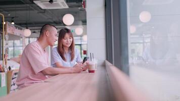 Couple talking about general matters, happy and taking care of each other, laughing and looking at smartphone. video