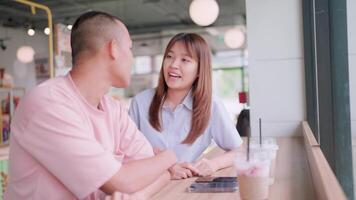 Pareja gasto hora juntos en un café contento parejas sentado en un de madera mesa hablando y sonriente a cada otro en un romántico fecha. video