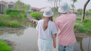 fechar-se do uma casal segurando mãos enquanto caminhando através a quintal, mostrando seus amor para cada outro. e Faz vários Atividades romântico conceito video