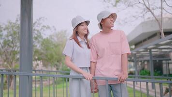 Young tourists from different nationalities stand together in a new city holding hands. Point at buildings and talk about architecture. video