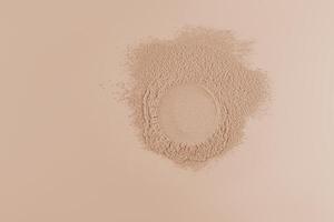 An empty round space on loose powder in a natural beige color. Advertising concept of the product. Top view. space for text. Beige background photo