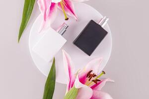 Two luxurious matte perfume bottles or sprays on a white round podium. lily. black and white bottle. masculine and feminine essence. Top view photo