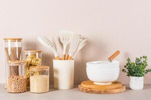 hermosa cocina antecedentes con abultar comida almacenamiento área, cucharas y Cocinando herramientas y verde planta en un maceta. frente vista. foto