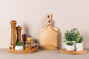 conjunto de de madera especia molinos y vaso frascos con especias en un redondo mimbre bandeja en un Roca encimera en el interior de un moderno cocina espacio. foto