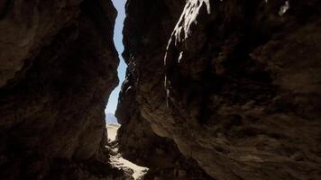 The sun is shining through a narrow opening in a cave video