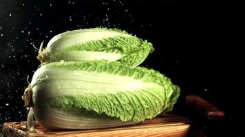 Drops of water fall on Beijing cabbage. On a black background. Filmed is slow motion 1000 fps. video