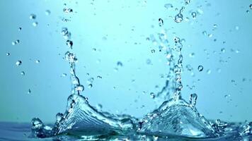 A closeup shot of a water drop splashing on a transparent glass surface, creating a mesmerizing electric blue effect against the sky backdrop video