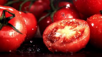 Assortment of tomatoes, including a halved one. These red fruits are versatile ingredients in recipes and are known for their natural healthy properties as a superfood video