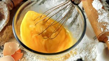 Liquid ingredients are being whisked in a glass bowl for a recipe. The fluid mixture takes on an amber hue as it transforms into a delightful dish video