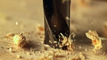 Super slow motion drill is made in a hole in a tree with sawdust. High quality FullHD footage video