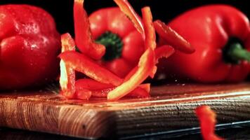 Super slow motion chopped sweet peppers fall on a cutting board. High quality FullHD footage video