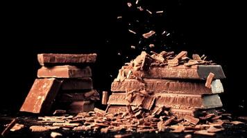 Super slow motion fall of grated, milk chocolate on a pyramid of chocolate slices. High quality FullHD footage video