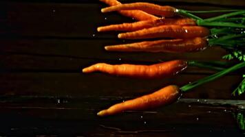 Super slow motion fresh carrots fall on the table. High quality FullHD footage video