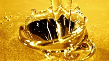 Super slow motion olive oil pours in a stream with splashes. High quality FullHD footage video