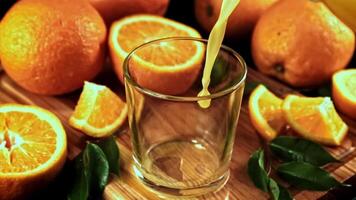 naranja jugo con salpicaduras es vertido dentro el vaso. alto calidad full HD imágenes video