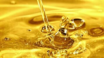 Super slow motion olive oil pours in a stream with splashes. High quality FullHD footage video