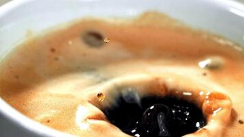 Close up of a cup of coffee with a hole in it, showcasing the liquid ingredient seeping out. A tempting sight for any terrestrial animal in need of comfort food video