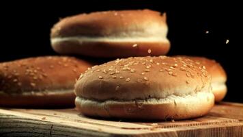 Sesame falls on burger buns. On a black background. Filmed is slow motion 1000 frames per second. High quality FullHD footage video