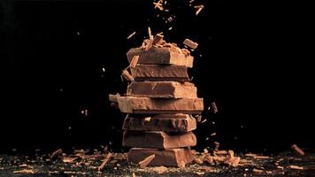 Super schleppend Bewegung fallen von gerieben, Milch Schokolade auf ein Pyramide von Schokolade Scheiben. gefilmt auf ein schnelle Geschwindigkeit Kamera beim 1000 fps. hoch Qualität fullhd Aufnahmen video
