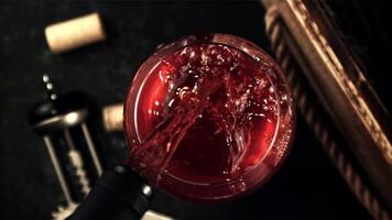 Super schleppend Bewegung im das Glas gießen rot Wein. auf ein schwarz Hintergrund. oben Sicht. gefilmt auf ein schnelle Geschwindigkeit Kamera beim 1000 fps. video