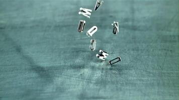 The letters of the English alphabet fall on the table. On a gray background. Filmed is slow motion 1000 frames per second. video