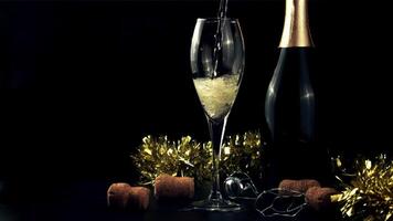 A stream of champagne pours into the glass. On a black background. Filmed is slow motion 1000 fps. High quality FullHD footage video