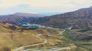 Aerial. scenic mountain road from a pass to alpine lake in spring mountain video