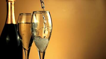 festeggiare il nuovo anno. un' ruscello di Champagne versa in il bicchiere. su un' giallo sfondo. girato è lento movimento 1000 fps. alto qualità FullHD metraggio video