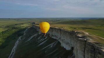 une Jaune ballon mouches dans le ciel plus de le blanc Roche dans le Crimée. drone vue video