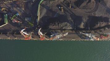 Mooring wall of the port of the sea cargo terminal with port cranes. Drone view video