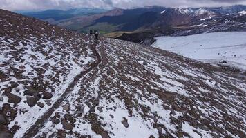 Aerial view. group of hikers descending a path that runs along a volcanic slope video