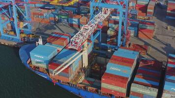 The port crane lifts the container from the truck and loads it into the hold video