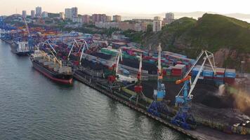 Cargo ship and a bulk carrier, standing at the quay wall, are loaded in the port video