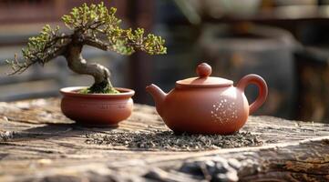 Traditional teapot made from red clay placed on an old wooden table. photo