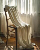 White towel draped over the back of a wooden chair photo