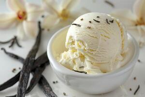 vainilla hielo crema, vainilla frijoles y vainilla flores en el mesa. foto