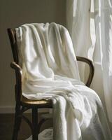 White towel draped over the back of a wooden chair photo
