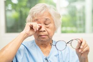 Asian senior woman with eyeglasses or vision glasses at home care service. photo