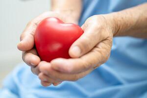 Doctor holding a red heart in hospital, healthy strong medical concept. photo