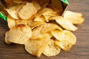 Potato chips, delicious spicy for crips, thin slice deep fried snack fast food in open bag. photo