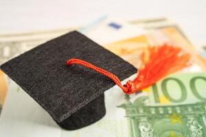 Sombrero de brecha de graduación en billetes de euro y dólar estadounidense, concepto de enseñanza de aprendizaje de tarifa de estudio de educación. foto