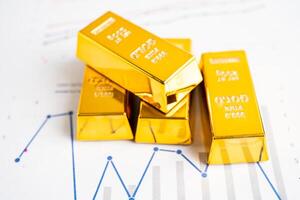 Gold bar on graph, economy finance exchange trade investment concept. photo