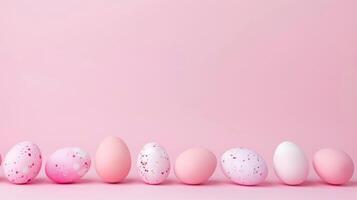 Row of pink and white eggs on pink background photo