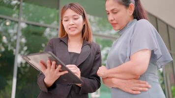 Smiling business couple with friend using laptop in office meeting presentation video