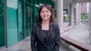 Close-up of happy Asian woman looking at camera Smiling businessman's face, company employee, manager and startup entrepreneur, company head at office video