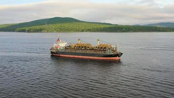 Aerial. Cargo ship in motion with construction equipment on deck video