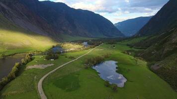 Aerial. Green Chulyshman Valley with a river, mountains and a road video