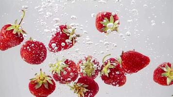 bunch of strawberries falling through water 4k background video