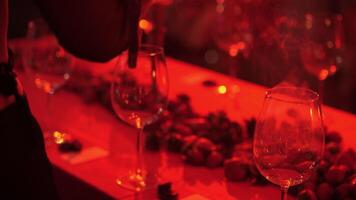 girl fumigates empty wine glasses with palo santo aroma sticks in red light video